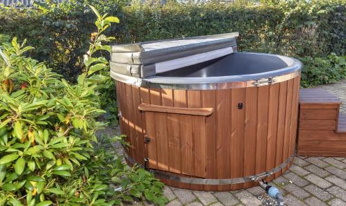 a wooden barrel with a sink in a garden at Lovely Holiday Home With Hot Tub 150 M To Water in Fur