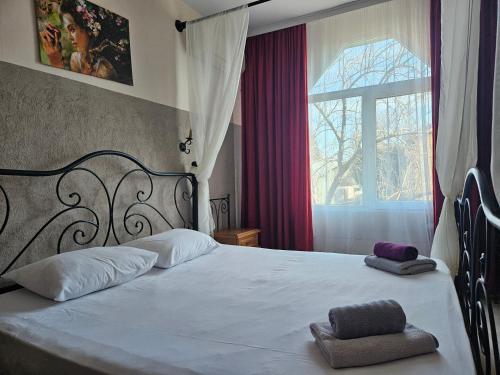 Un dormitorio con una cama grande con dos toallas encima. en Paralax Hotel, en Varna