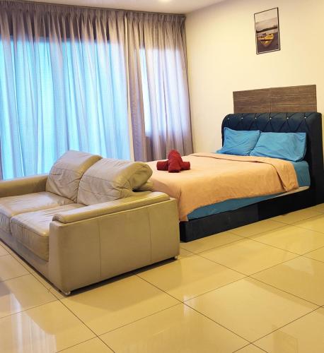 1 dormitorio con 1 cama y 1 sofá junto a una ventana en Trefoil Studio Unit Setia Alam, en Shah Alam