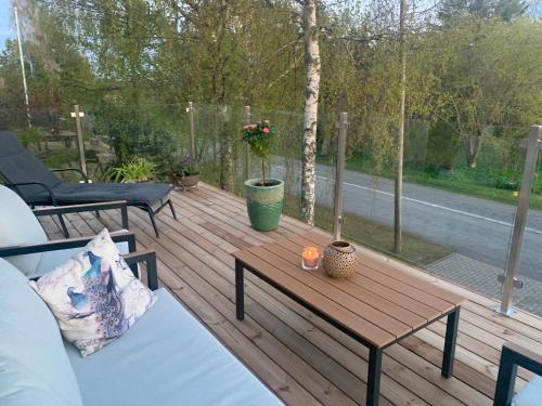 a wooden deck with a table and a candle on it at Villa Mariett in Kuressaare