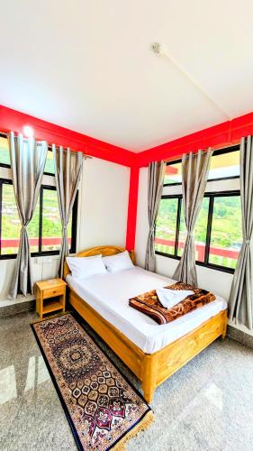 a bedroom with a bed in a room with windows at Lhamu homestay in Chug