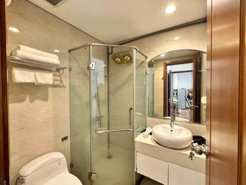 a bathroom with a shower and a toilet and a sink at Royal City Apartment Ha Noi by Luxe Hospitality in Hanoi