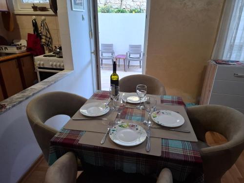 einen Tisch mit einer Flasche Wein darüber in der Unterkunft Apartment with private yard in Petrovac in Petrovac na Moru