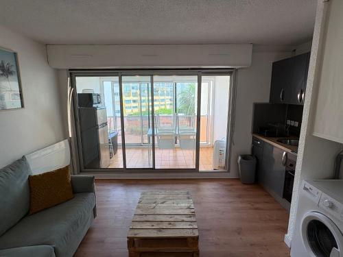 un salon avec un canapé et une table dans l'établissement HELiOS, au Cap d'Agde