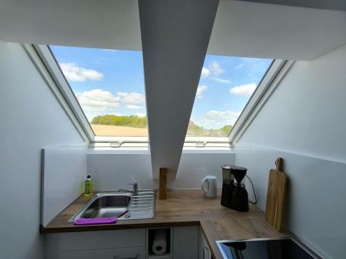 a kitchen with a skylight and a sink in a room at Ferienwohnung "Grüne Auszeit" in Groß Wokern