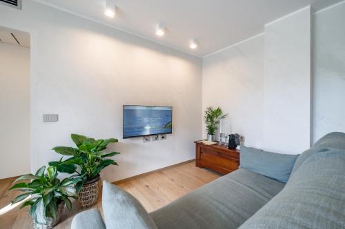 a living room with a couch and a tv on a wall at Villa Sunshine - Luxury property, with pool & large private garden, few steps from the beach, ideal for families, large groups and people with mobility issuess in Dervio