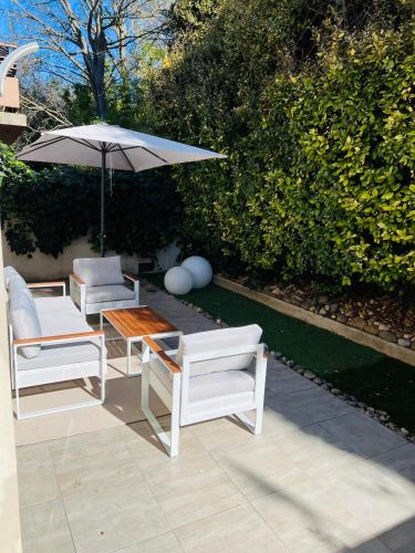 un patio avec deux chaises, une table et un parasol dans l'établissement Apartment with beautiful terrace, à LʼIsle-sur-la-Sorgue