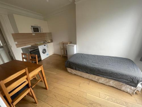- une chambre avec un lit, une table et un four micro-ondes dans l'établissement Odéon, à Paris