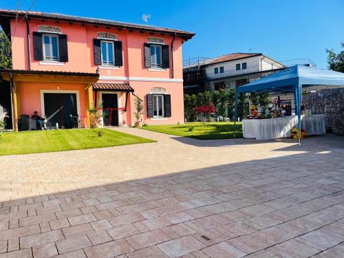 a house with a table and a blue tent at Airport Flower Rooms in Ronchi dei Legionari