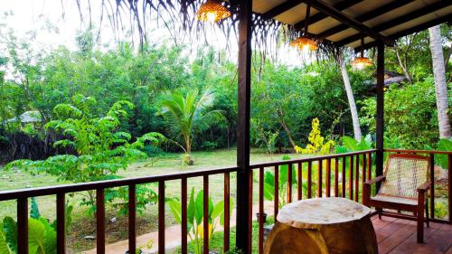 a porch with a table and a tree stump at Nature Rest Ashored in Sigiriya
