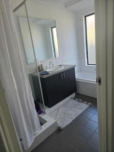 a bathroom with a sink and a mirror at Baldivis Basic Apartment in Baldivis