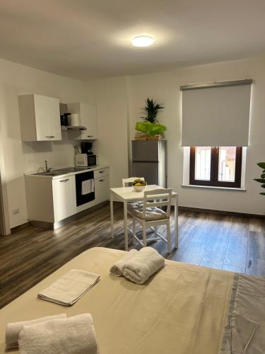 a living room with a table and a kitchen at Caprotti 6 in Magenta