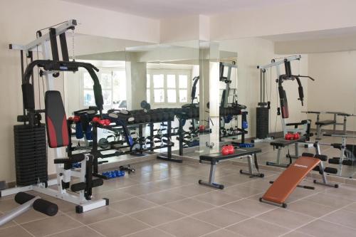 a gym with several tread machines in a room at Magnolia Apartments in Fiskardho