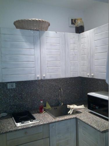 - un comptoir de cuisine avec des placards blancs et un évier dans l'établissement Croisette Luxury sea-view studio, à Cannes