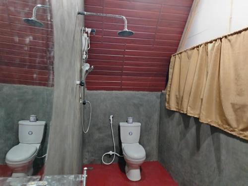 a bathroom with two toilets and a shower at Nature Rest Ashored in Sigiriya
