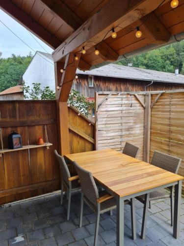 a wooden table and chairs on a patio at Ferienwohnungen am Ferienhof Schiegl - gerne auch Handwerker, Monteure in Brennberg