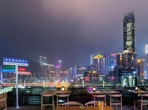 a city skyline at night with tables and chairs at 重庆大野江景民宿 in Chongqing