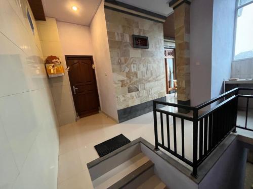 a hallway with stairs and a door in a building at Twowi House Ubud in Ubud