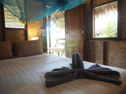 a bedroom with a bed with a towel on it at LITTLE EDEN Bungalows in Ko Chang