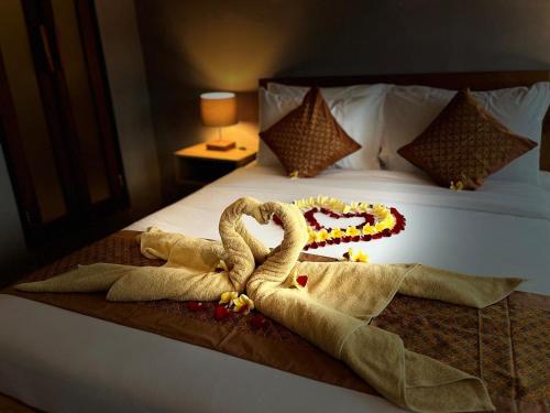 a bed with two swans made out of towels at Twowi House Ubud in Ubud