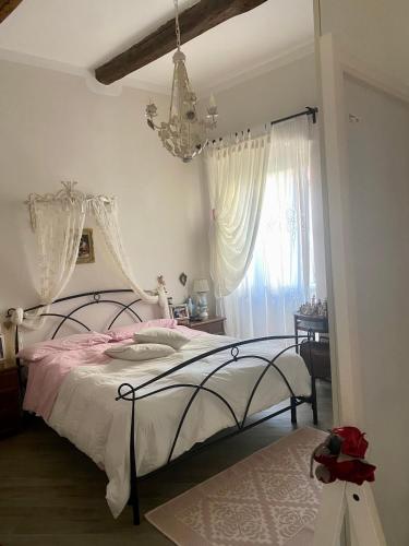 a bedroom with a bed and a chandelier at Casa da Ida in Portoferraio
