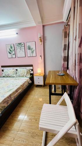a bedroom with a bed and a table and a chair at Studio Kéo lưới in Hanoi