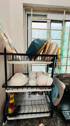 a shelf with dishes and bowls on it at Studio Kéo lưới in Hanoi