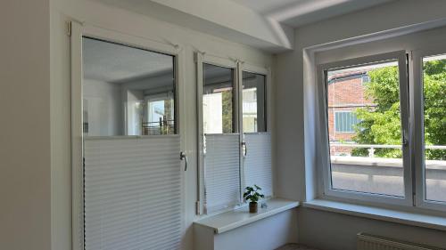 Habitación con 3 ventanas con persianas blancas en City Apartement Linz für 5 Gäste mit self-checkin und Küche, en Linz