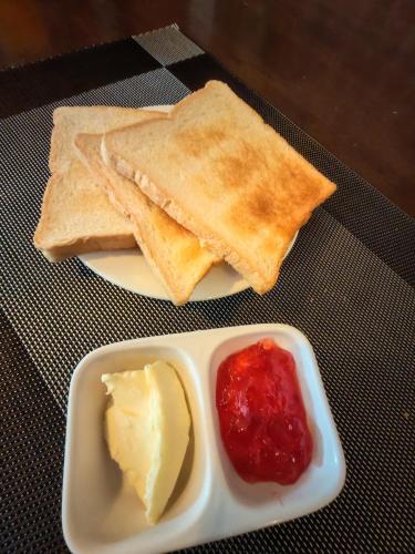 ein Teller Toast mit Butter und Marmelade und Butter in der Unterkunft Jardin in Pattaya South