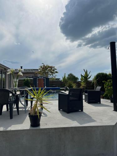 a patio with chairs and a table and a pool at Chambre avec vue sur le marais et la piscine in Yves