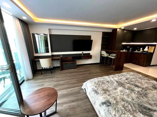 バトゥミにあるBatumi View Apartmentsのベッドと薄型テレビがあるホテルの部屋