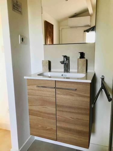 une salle de bain avec un lavabo et un miroir dans l'établissement Maisonnette au calme dans résidence avec piscine, à Saint-Rémy-de-Provence