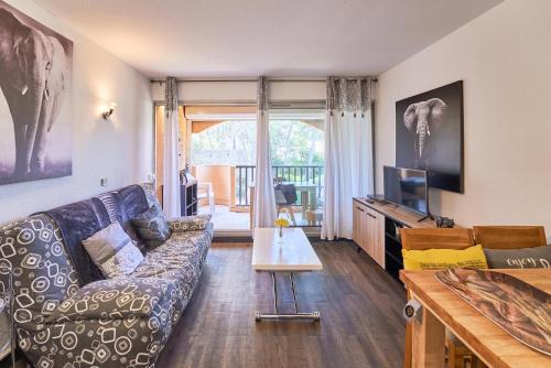 a living room with a couch and a tv at Évasion aux Cystes - Piscine & terrasse in Sanary-sur-Mer