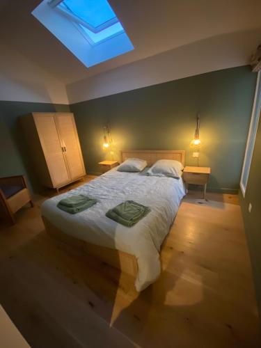 une chambre avec un grand lit avec une lucarne dans l'établissement La Villa Moon, à Lacanau-Océan