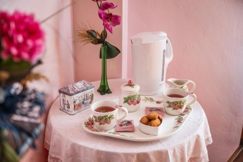 a table with two cups of tea and a tray of pastries at La Meira di Lucia B&B in Rossana