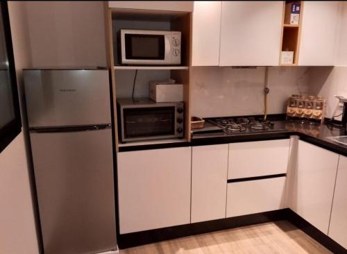 a kitchen with a stainless steel refrigerator and microwave at Superbe S2 richement meuble Marsa in Sidi Daoud