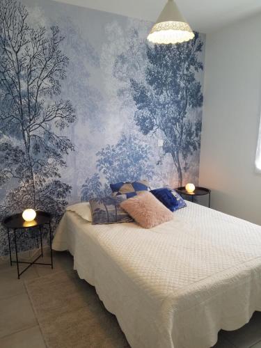 - une chambre avec un lit et du papier peint bleu dans l'établissement Maison spacieuse avec jardin clos au calme, à Bergerac