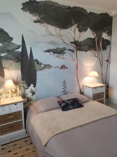 - une chambre avec un lit orné d'une fresque murale sur les arbres dans l'établissement Maison spacieuse avec jardin clos au calme, à Bergerac