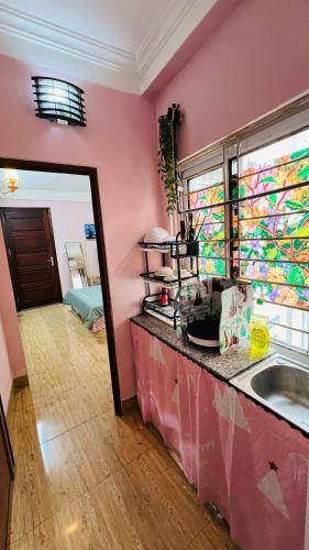 a pink room with a counter and a sink at Studio Kéo lưới in Hanoi