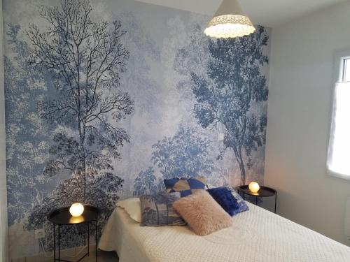 - une chambre avec un lit et du papier peint bleu dans l'établissement Maison spacieuse avec jardin clos au calme, à Bergerac