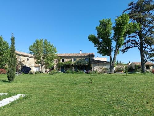 a large yard with a house and a tree at La Bohême La Belle Etoile Petit déjeuner compris in Charols