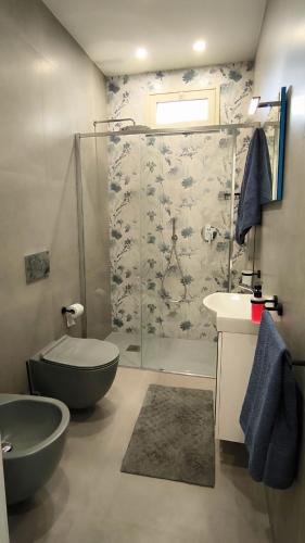 a bathroom with a shower and a toilet and a sink at La Villa Trinacria in Giardini Naxos