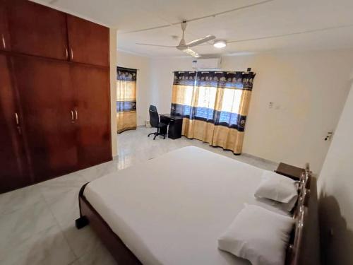a bedroom with a bed and a desk in it at Lashibi Villas in Teshi