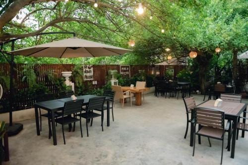 a patio with tables and chairs and an umbrella at Luang Prabang Inn 1 in Luang Prabang