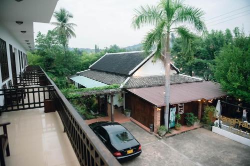 a car parked in front of a house with a palm tree at Luang Prabang Inn 1 in Luang Prabang