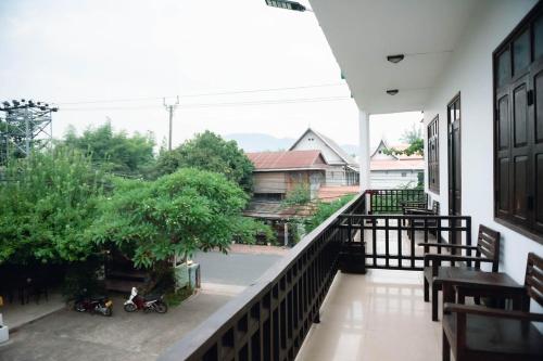 a balcony with chairs and a view of a building at Luang Prabang Inn 1 in Luang Prabang