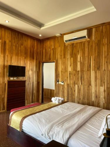 a bedroom with a large bed with wooden walls at Luang Prabang Inn 1 in Luang Prabang