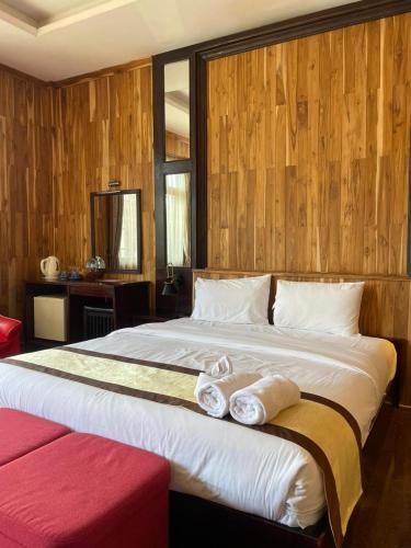 a bedroom with a large bed with two towels on it at Luang Prabang Inn 1 in Luang Prabang