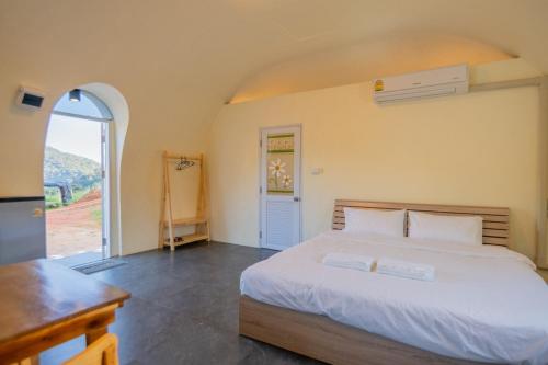 een slaapkamer met een groot bed en een open deur bij Dome In Doi in Mon Jam