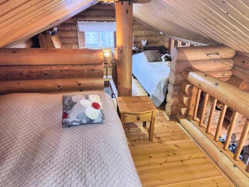 una camera con un letto in una baita di tronchi di Ainola Cottage ad Alapitkä